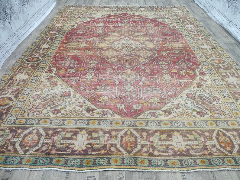 May include: A vintage Persian rug with a red, cream, and brown color scheme. The rug has a central medallion with intricate geometric patterns and a floral border.