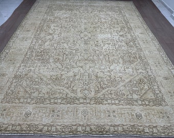 May include: A vintage cream-coloured rug with a detailed, intricate pattern in a darker brown colour. The rug has a traditional design with a central medallion and a border.