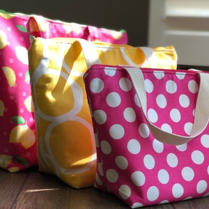 Peut inclure: Quatre sacs isothermes pour le d&eacute;jeuner avec fermeture &eacute;clair et poign&eacute;es. Les sacs sont en tissu et pr&eacute;sentent diff&eacute;rents motifs&nbsp;: rose &agrave; pois blancs, jaune &agrave; cercles blancs et rose &agrave; citrons.