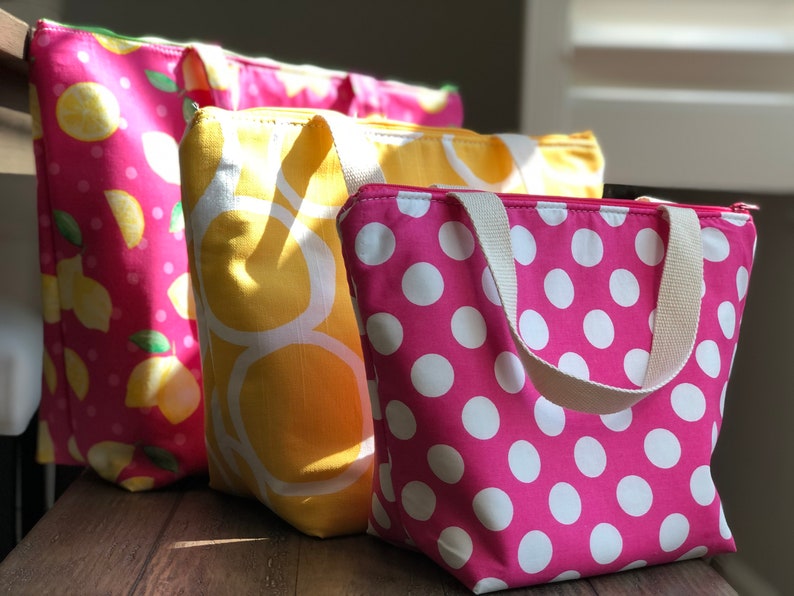 Peut inclure: Quatre sacs isothermes pour le d&eacute;jeuner avec fermeture &eacute;clair et poign&eacute;es. Les sacs sont en tissu et pr&eacute;sentent diff&eacute;rents motifs&nbsp;: rose &agrave; pois blancs, jaune &agrave; cercles blancs et rose &agrave; citrons.