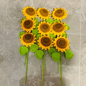 May include: A bouquet of crocheted sunflowers with green leaves. The sunflowers are yellow with brown centers.