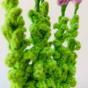 May include: Close-up of a crocheted bouquet of green flowers. The flowers are made with a textured, bumpy yarn.