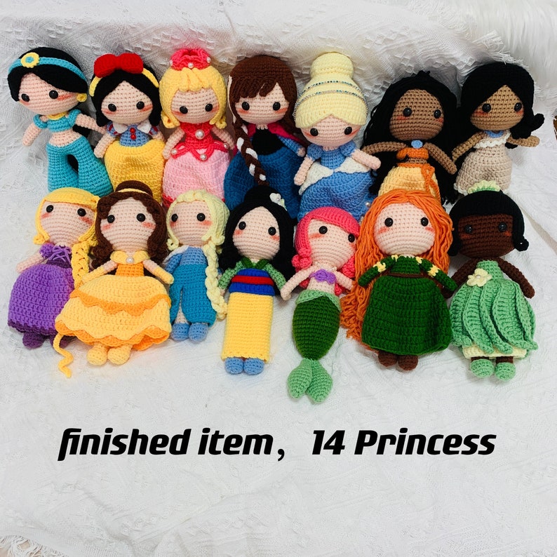 Peut inclure: Une collection de 14 poup&eacute;es princesses en crochet faites &agrave; la main. Les poup&eacute;es sont toutes de couleurs diff&eacute;rentes et ont des coiffures diff&eacute;rentes. Elles portent toutes des robes et certaines ont des couronnes. Les poup&eacute;es sont dispos&eacute;es en rang&eacute;e sur une surface blanche. "finished item, 14 Princess"
