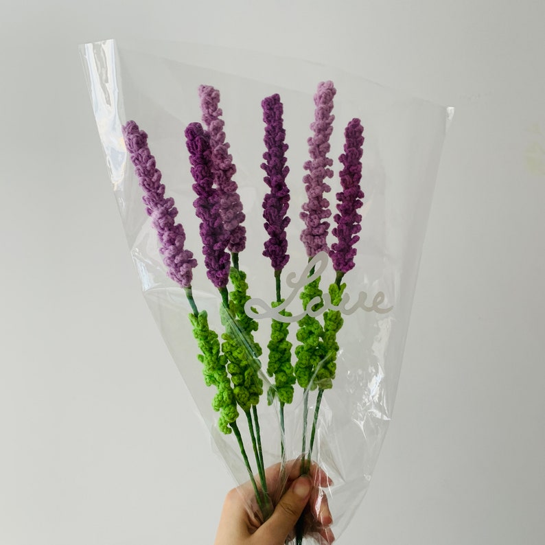 May include: A bouquet of purple and green crocheted lavender flowers in a clear plastic bag with the word "Love" written on it.
