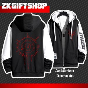 Puede incluir: Sudadera con capucha con cremallera en blanco y negro con un diseño gráfico rojo en la espalda y el pecho. Las mangas son blancas y la sudadera con capucha presenta el texto "BREVK" en una manga y "Astarion Aneunín" en la parte delantera.