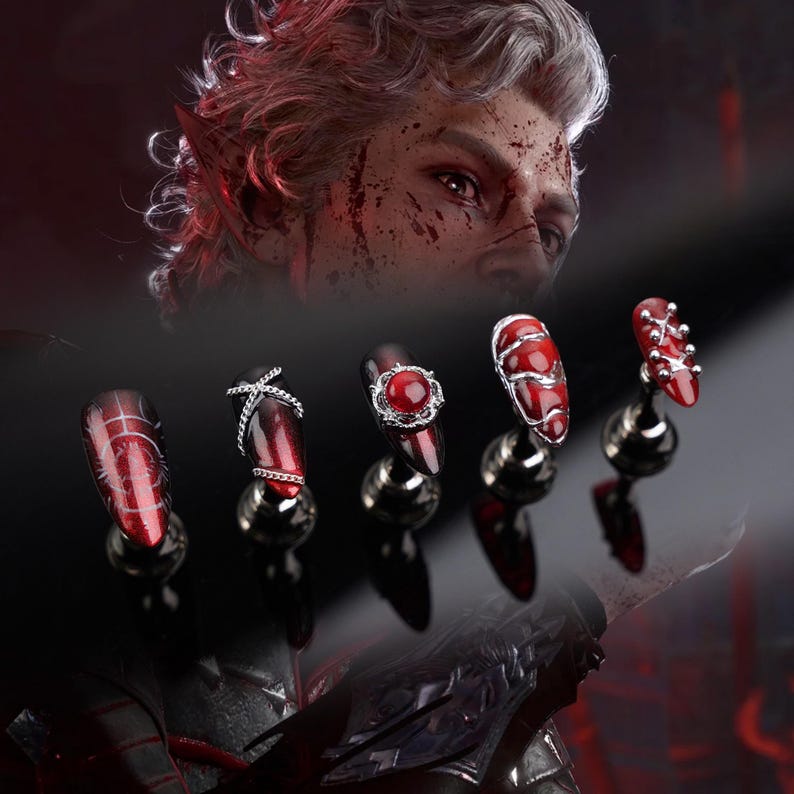 May include: Five red and black nail designs, each displayed on a silver stand. The nails are decorated with silver details and a central red gem. The background shows a person with white hair and red accents.