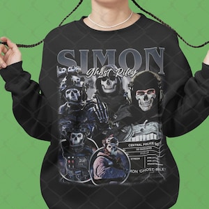 Könnte beinhalten: Schwarzer Pullover mit einem grafischen Druck einer Gruppe von Soldaten, die Totenkopfmasken tragen. Der Text "SIMON Ghost Riley" ist auf dem Pullover aufgedruckt.