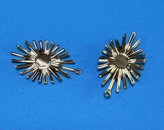 May include: Two silver-toned metal sunburst charms with a loop for attaching to jewelry or other crafts.