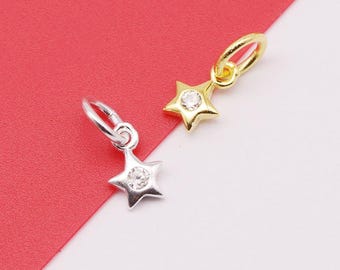 May include: Two silver star charms with a clear rhinestone in the center. The charms have a jump ring for attaching to a necklace or bracelet.