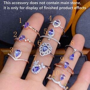 May include: Ten different silver rings featuring blue gemstones. Each ring boasts a unique design, including a heart, a flower, and a crown.