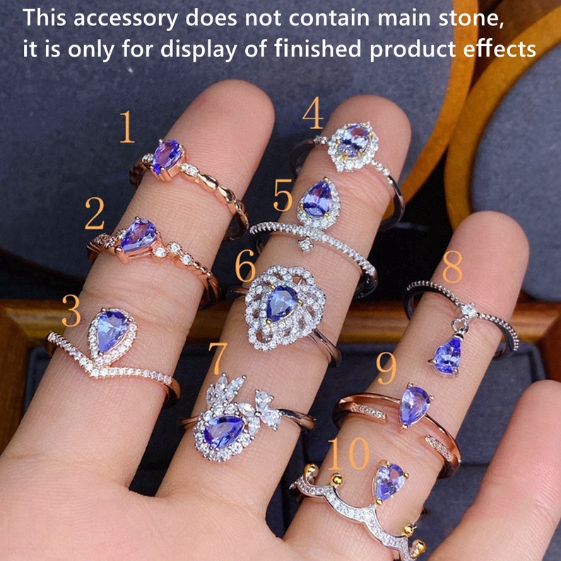 May include: Ten different silver rings featuring blue gemstones. Each ring boasts a unique design, including a heart, a flower, and a crown.