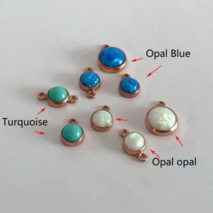 May include: Assortment of small, round, gemstone charms in turquoise, opal blue, and opal white. Each charm has a loop on either side for attaching to jewelry.