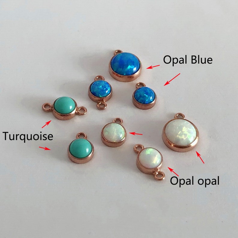 May include: Assortment of small, round, gemstone charms in turquoise, opal blue, and opal white. Each charm has a loop on either side for attaching to jewelry.