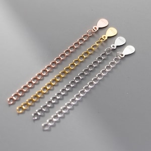 May include: Four silver chain extenders in different colors: rose gold, gold, silver, and white gold. Each extender has a small tag with the word "925" on it.