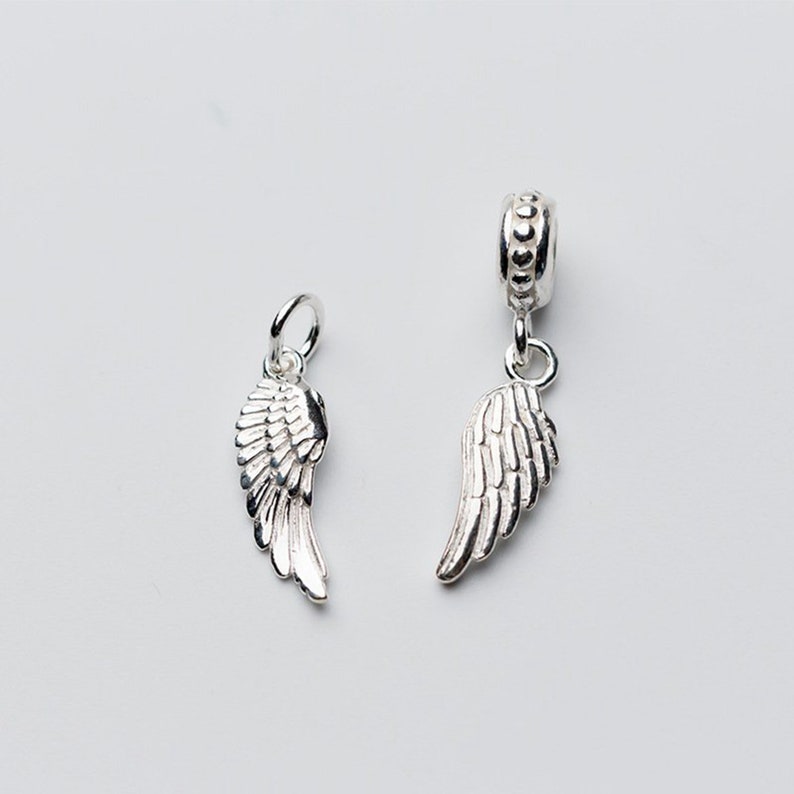 Puede incluir: Dos abalorios de alas de &aacute;ngel de plata, uno con una anilla de cuentas y otro con un simple bucle. Las alas est&aacute;n detalladas con plumas texturizadas.