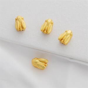 Peut inclure: Quatre breloques en forme de lapin de couleur dorée. Les breloques sont petites et détaillées, avec un design tridimensionnel. Elles sont parfaites pour ajouter une touche de fantaisie à des bijoux ou des objets artisanaux.