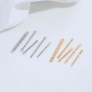 May include: A collection of ten metal jewelry connector bars arranged in two groups. Five silver-toned bars and five gold-toned bars feature textured, twisted surfaces with small circular loops at each end for attachment in jewelry making.