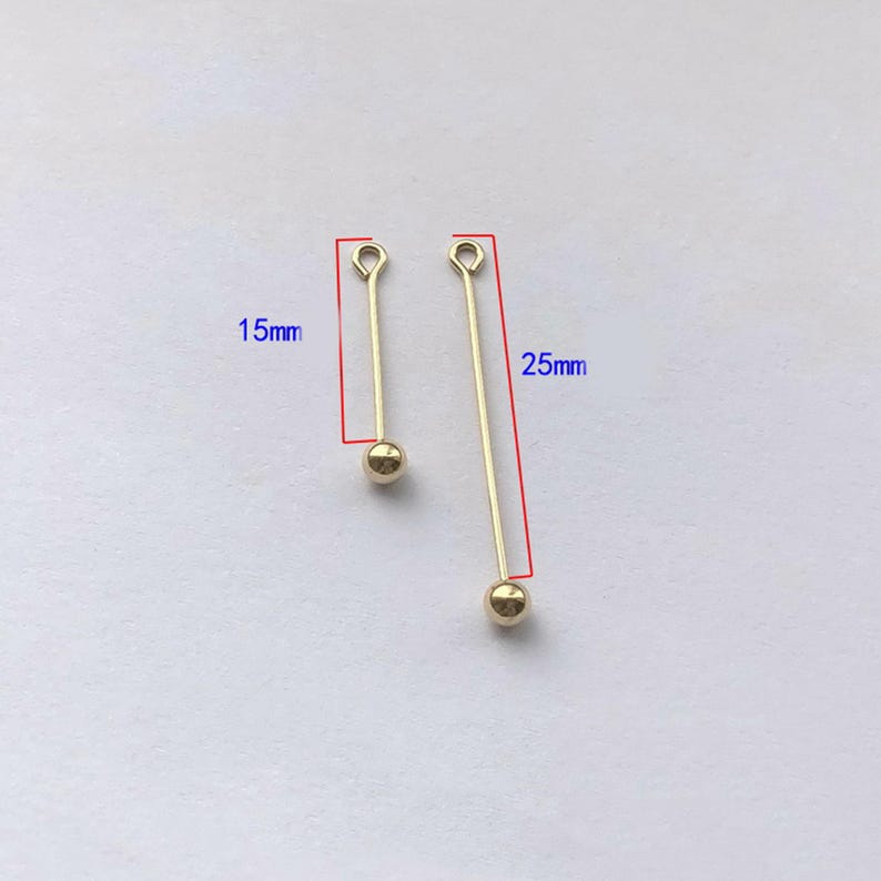 Peut inclure: Deux appr&ecirc;ts de bijoux dor&eacute;s. L'un mesure 1,5 cm de long, l'autre 2,5 cm. Chacun a une petite boucle en haut et une perle ronde en bas. Les appr&ecirc;ts sont con&ccedil;us pour la fabrication de bijoux.
