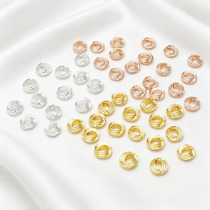 Può includere: Una collezione di piccole perline metalliche rotonde caratterizzate da una trama intrecciata simile a una corda. Le perline sono disposte in tre distinti gruppi di colore: argento, oro e oro rosa, ciascuna con un foro centrale per l'infilatura.
