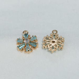 Gouden sneeuwvlokbedel met blauwe edelsteenaccenten - Aanbod wintersieraden