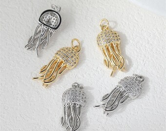 May include: Five jellyfish-shaped pendants in gold and silver tones. The pendants feature a domed head encrusted with small, clear stones and flowing tentacles. The pendants are designed for jewelry making.