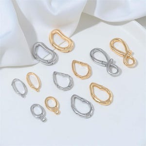 May include: A white ceramic mug with a black handle and the text "But First, Coffee" in a bold, black font. The mug is set against a blurred background, suggesting a cozy setting.