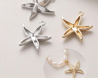 May include: Three starfish charms in silver and gold tones. One gold starfish is attached to a pearl necklace. The charms have a loop at the top for easy attachment to jewelry or other crafts. The starfish are a nautical theme.