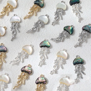 May include: A collection of jellyfish-shaped pendants. Some are gold-toned with abalone shells, others are silver-toned with mother-of-pearl shells. Each pendant has delicate, flowing tentacles and small, sparkling accents.