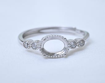 Anillo ajustable de plata de ley con detalles de circonita cúbica, engaste de piedra ovalada de 5 x 7 mm.