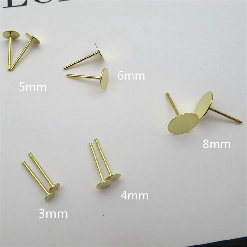 Peut inclure: Assortiment de tiges d'oreilles dor&eacute;es avec des bases rondes en m&eacute;tal de diff&eacute;rentes tailles. Les bases ont un diam&egrave;tre de 3 mm, 4 mm, 5 mm, 6 mm et 8 mm.