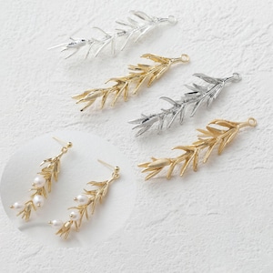 Può includere: Un assortimento di componenti per gioielli a forma di foglia dorata e argentata. Sono visibili anche due paia di orecchini dorati con dettagli di perle. I componenti sono progettati per la creazione di gioielli e l'artigianato.
