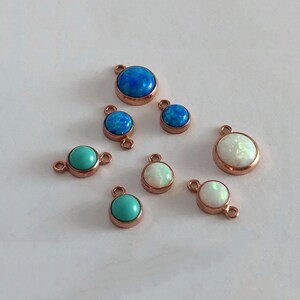 May include: Assortment of small round opal and turquoise gemstone pendants with rose gold settings. The pendants have a single loop or double loops for attaching to jewelry.