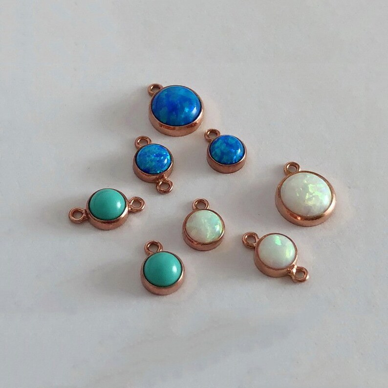 May include: Assortment of small round opal and turquoise gemstone pendants with rose gold settings. The pendants have a single loop or double loops for attaching to jewelry.