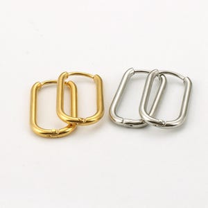 Könnte beinhalten: Zwei Paare rechteckiger Creolen, ein Paar in Gold und ein Paar in Silber.