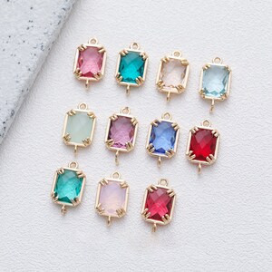 May include: Assortment of 10 gold-toned charms featuring faceted glass stones in various colours, including pink, green, blue, red, and clear. Each charm has a loop for attaching to jewellery or other crafts.