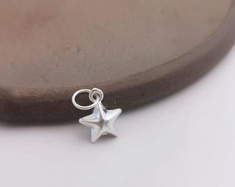 May include: A silver star charm with a loop for attaching to a necklace or bracelet.
