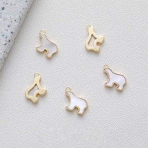 May include: Five gold-tone metal charms shaped like polar bears. Each charm has a white mother-of-pearl inlay. The charms are perfect for adding a touch of whimsy to jewelry or crafts.
