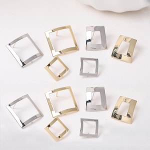 May include: An assortment of square-shaped stud earrings in gold and silver tones. The earrings have an open, geometric design, with a post for insertion into the ear. The earrings are displayed on a white surface.