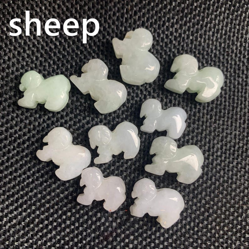 Pode incluir: Uma cole&ccedil;&atilde;o de pequenas figuras de ovelhas verdes claras e brancas. A palavra "sheep" est&aacute; escrita em letras brancas no canto superior esquerdo. As figuras s&atilde;o esculpidas com detalhes e dispostas sobre uma superf&iacute;cie texturizada cinza escuro.