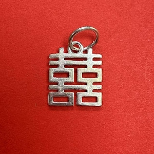 May include: Silver charm with a double happiness symbol, a traditional Chinese design often used for weddings and good luck.