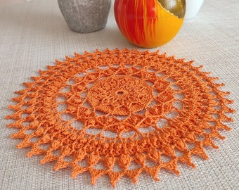 Bright and cheerful round orange crochet doily with a lot of textured 3D elements