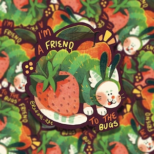 May include: A white cat wearing a green bug costume with a strawberry and leaves. The cat is smiling and the text says "I'm a friend to the bugs".