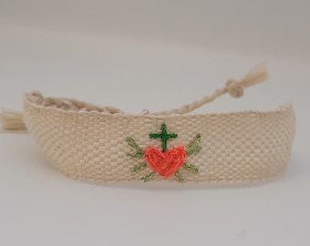 Hand-woven bracelet: The "Sacred Heart of Spring", white silk ribbon, neon pink cotton heart embroidery, cotton and green lurex.