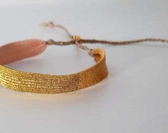 Le "Douceur de l'enfance" : Bracelet tissé à la main, en fil rose pale, fil moutarde et fil doré.