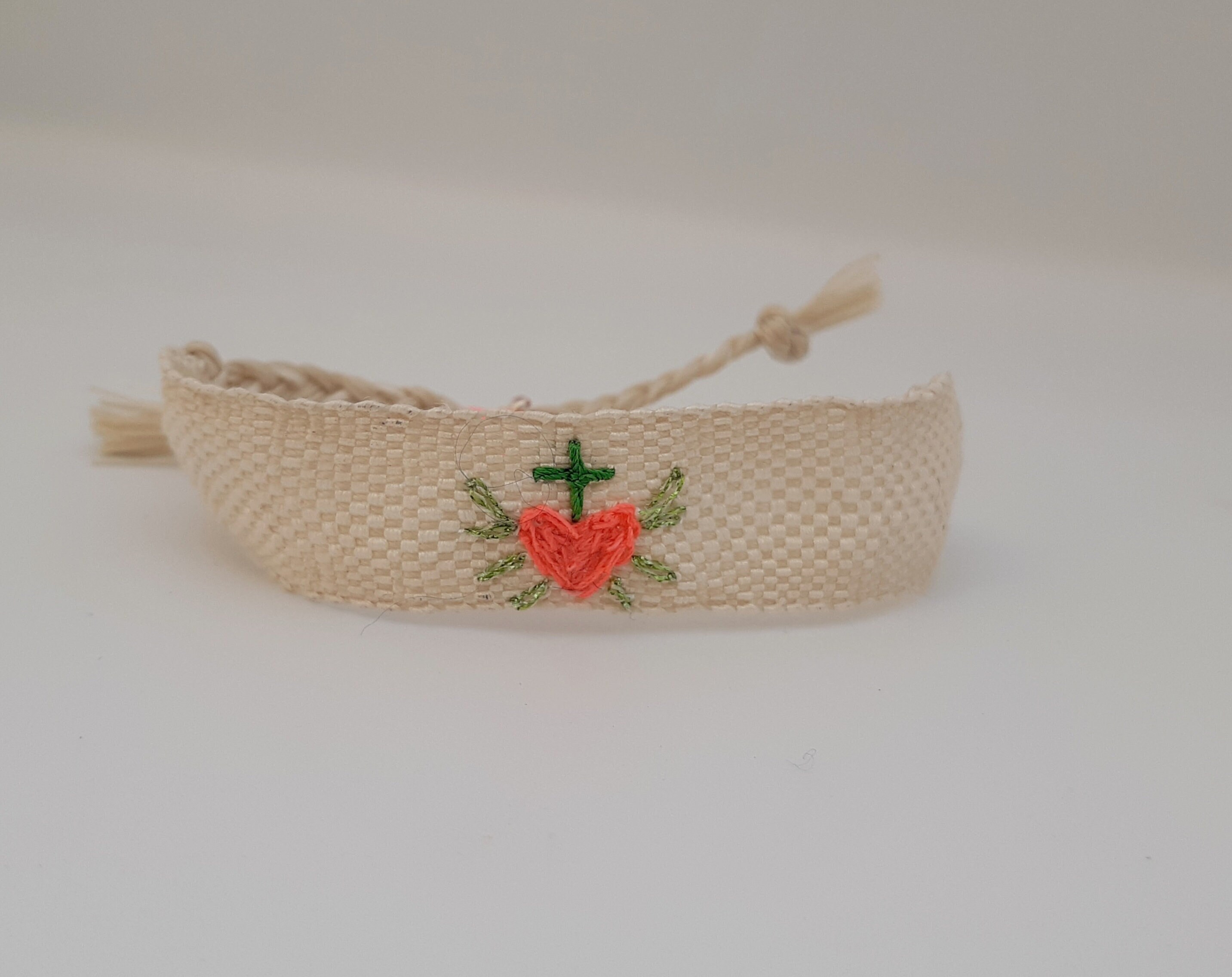 Hand-woven bracelet: The "Sacred Heart of Spring", white silk ribbon, neon pink cotton heart embroidery, cotton and green lurex.