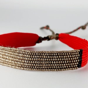 the "Castanettes in Seville": Hand-woven bracelet, in light olive silk thread, red vintage thread, black lurex thread.