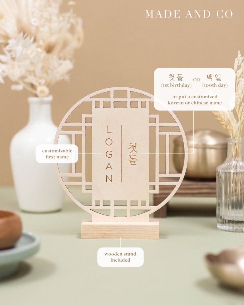 May include: A wooden sign with a traditional Korean design, featuring a customizable first name and the text "첫돌" (meaning "first birthday") or "백일" (meaning "100th day"). The sign comes with a wooden stand.