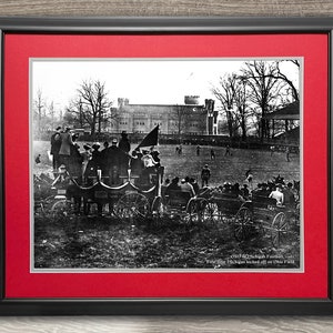 May include: A black and white photograph of a football game from 1901. The image shows a group of people in horse-drawn carriages watching the game. The text below the image reads "1901 Univ. of Michigan Football, 1901. First game Michigan kicked off on Ohio Field."