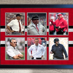 May include: A framed collage of six photos of different football coaches. The photos are arranged in a grid of two rows and three columns. Each photo is set against a red background with a white and black striped border. The coaches are all wearing different clothing, but they all have serious expressions on their faces.