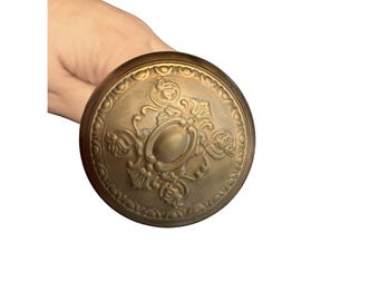 Set di pomelli per porta in ottone anticato con design decorato e perno di collegamento.